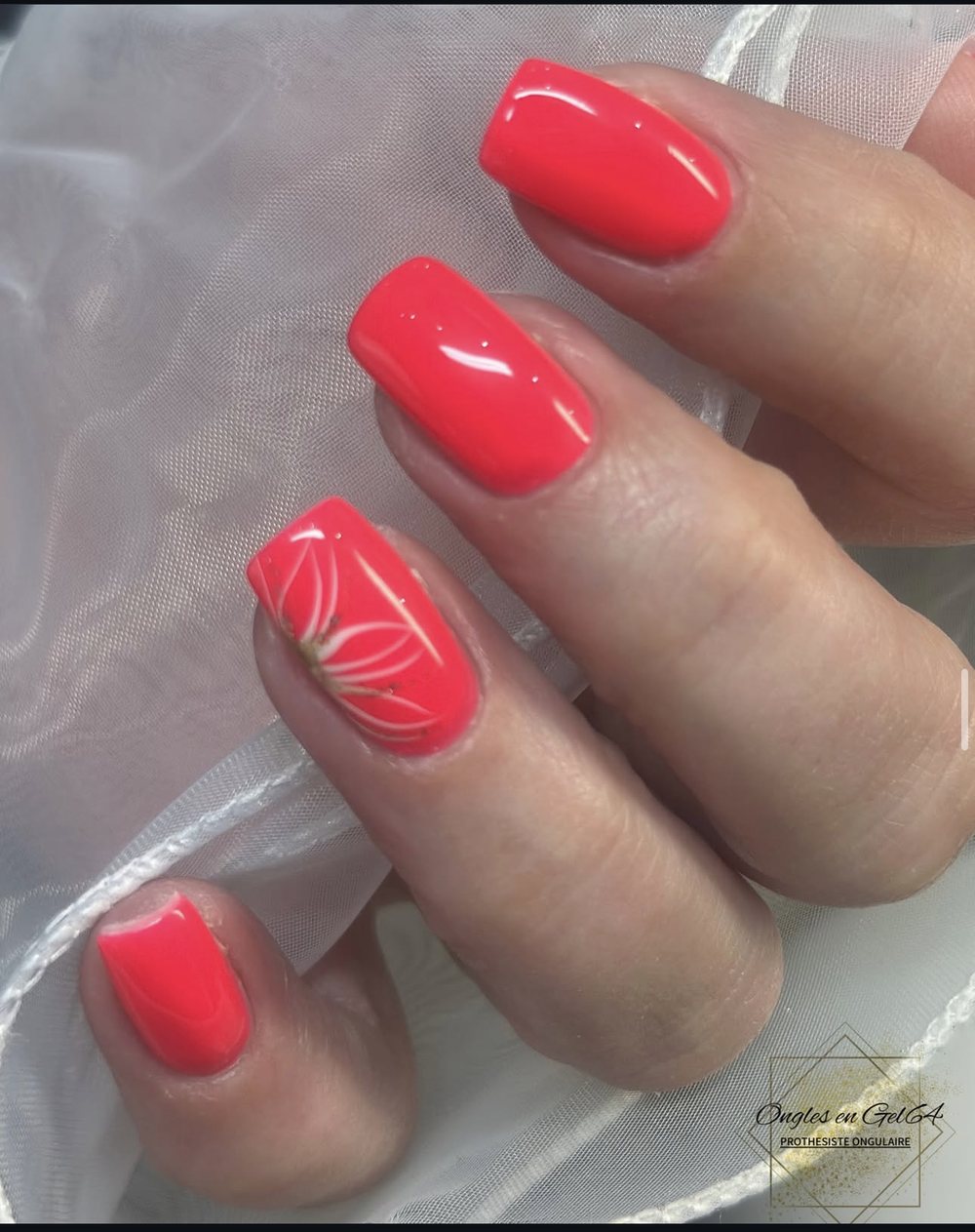 Ongles corail flash avec motif fleur blanche